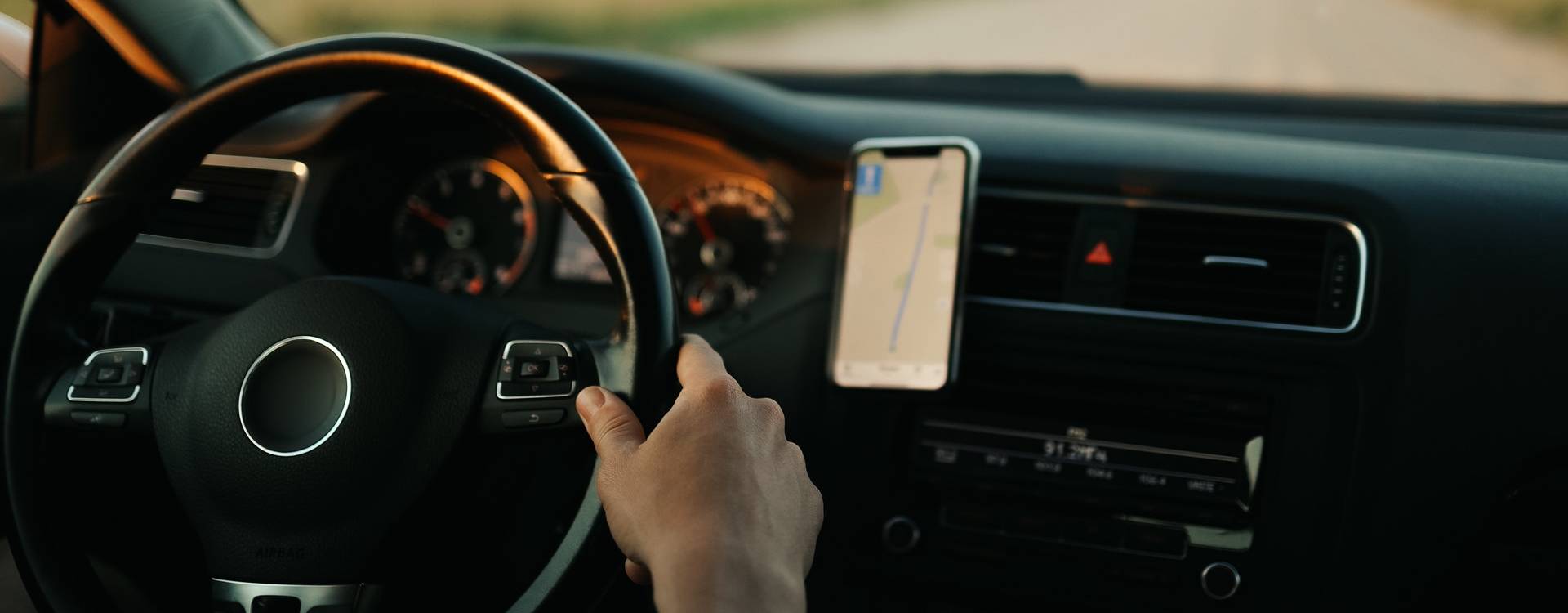 A hand holding a phone in a car coordinating volunteer activities